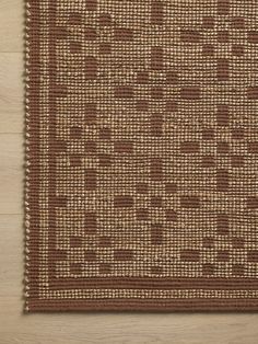 a brown and white rug on top of a wooden floor