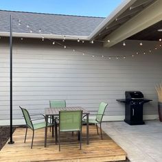 an outdoor patio with table, chairs and grill