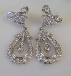 Metal: 14kt White Gold Stone: Diamond Stone Shape: Round Diamond Weight: 1.50 ctw Type Of Backing: Push Back Dimensions Of Earrings From Top To Bottom: 49.00mm Weight of entire piece with stones: 14.40 grams Link For Matching Pendant: https://www.etsy.com/BFJewelryEst1984/listing/649357582/14kt-white-gold-vintage-style-diamond?utm_source=Copy&utm_medium=ListingManager&utm_campaign=Share&utm_term=so.lmsm&share_time=1680391173978 Brilliant Cut Diamond Dangle Earrings For Anniversary, Classic Platinum Pear-shaped Diamond Earrings, Classic Hand-set Diamond White Earrings, Formal Hand Set Teardrop Diamond Earrings, Exquisite Diamond Dangle Earrings For Anniversary, Elegant Platinum Diamond Earrings For Anniversary, Platinum Pear-shaped Diamond Earrings For Formal Occasions, Hand-set White Gold Diamond Earrings In Platinum, Elegant Hallmarked Pear-shaped Diamond Earrings