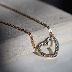 This elegant necklace features an open heart design, studded with CZ stones for a touch of sparkle. Perfect for adding a touch of love and glamour to any outfit. -stainless steel, gold plated -15.5" in length with 2" extender Gold Jewelry With Diamond Accents And Open Heart Shape, Elegant Metal Heart Cut Necklace, Gold Necklaces With Sparkling Stones For Valentine's Day, Gold Open Heart Necklace For Party, Gold Heart Cut Necklace For Party, Gold Jewelry With Diamond Accents In Open Heart Shape, Stainless Steel Heart Jewelry For Party, Elegant Heart Cut Metal Necklace, Heart Shaped Stainless Steel Party Jewelry