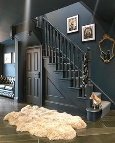 a living room with stairs and pictures on the wall