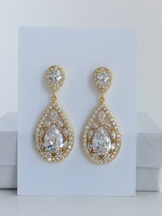 Super sparkely clear cubic zirconia bridal teardrop jewelry set in gold plated brass setting. This set includes: # Super sparkly earrings # I've created these truly amazing earrings with delicately detailed clear cubic zirconia teardrop that dangles from a cubic zirconia detailed teardrop ear stud. Total length of the earrings is 4.2 cms. # Super sparkly necklace# Necklace pendant features delicately detailed super sparkly teardrop with clear cubic zirconia crystals and dangles from cubic zircon Gold Diamond Teardrop Earrings For Anniversary, Gold Diamond Bridal Earrings With Sparkling Stones, Pear-shaped Diamond Accented Bridal Earrings, Pear-shaped Bridal Earrings With Diamond Accents, Gold Bridal Earrings With Sparkling Cubic Zirconia, Formal Gold Diamond Teardrop Earrings, Gold Diamond Teardrop Earrings For Wedding, Pear-shaped Teardrop Earrings With Diamond Accents For Wedding, Gold Cubic Zirconia Bridal Earrings