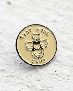 a badge with cats on it that says stay home club in gold and black lettering