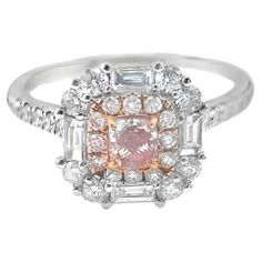 a pink and white diamond ring with two baguets in the center, surrounded by diamonds