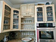 a kitchen with white cabinets and silver appliances