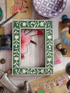 a wooden frame sitting on top of a table filled with assorted crafts and other items