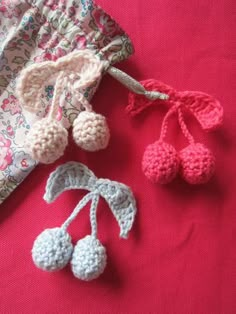 three crocheted items are laying on a pink surface