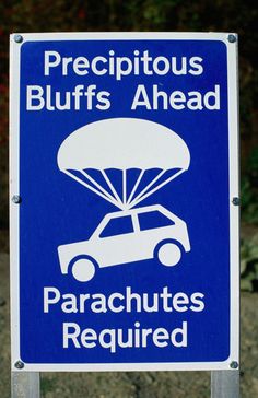 a blue sign that says, precious bluffs ahead parachutes required