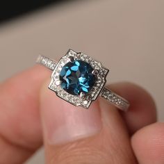 This is a gorgeous handmade creation. Its beauty is its simplicity & Elegance. The 7*7mm round cut London blue topaz is crafted in solid sterling silver and with rhodium plated. All item is sent in a beautiful gift box You can realize more lovely stuff clicking the link https://www.etsy.com/shop/knightjewelry?refshopsection_shophome_leftnav Please leave the correct address and you phone number for delivering successfully. Luxury Sterling Silver Topaz Promise Ring, Sapphire-colored Topaz Ring With Round Cut, Blue Topaz Ring With Halo Setting, Elegant Round Blue Topaz Ring, Luxury Sterling Silver Topaz Ring, Fine Jewelry Blue Topaz Halo Ring, Blue Gemstone Halo Ring In Sterling Silver, Luxury Topaz Promise Ring With Birthstone, Blue Gemstone Sterling Silver Halo Ring