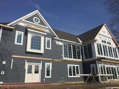 a house being built with windows and sidings on the front of it, in winter