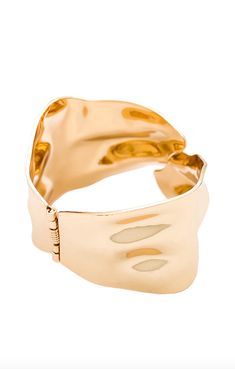 The Abstract Textured Cuff Bracelet in Gold is a must-have for the modern woman who exudes elegance and grace. Crafted with a touch of magic, these bracelets effortlessly elevate any outfit, adding a golden glow to your wrist. Embrace your inner goddess and shine with confidence. And layer it up. These bracelets were made for it. 18k gold-plated steel Hinge closure Textured effect Measures approx 2.4" in diameter Steel base: Provides durability and strength Chic Gold-tone Cuff Bangle Bracelet, Gold Cuff Bangle For Evening, Luxury Yellow Gold Metal Cuff Bracelet, Elegant Silver Gold-plated Cuff Bracelet, Chic Yellow Gold Bracelet, Luxury Gold Open Cuff Bangle, Chic Gold Bracelets With Oyster Detail, Chic Gold Cuff Bracelet With Bracelet Strap, Chic Rose Gold Metal Cuff Bracelet