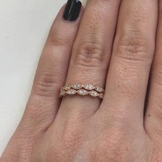 a woman's hand with a diamond ring on her left hand and black fingernails