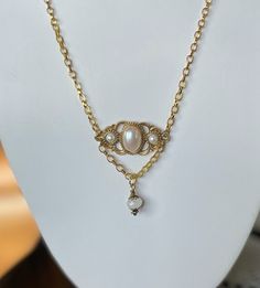 This lovely vintage gold and faux pearl brooch is reminiscent of the Sarah Coventry jewelry that was so popular in the late 60's and early 70's. It also has a Victorian vibe that is sweet and lovely. A pretty cut bezel glass bead was added as an extra bit of sparkle and dangles from a length of gold chain. This necklace has an 18" chain. Vintage Gold Pearl Jewelry, Vintage Gold Brooch With Pearl Pendant, Vintage Gold Jewelry With Pearl Charm, Vintage Pearl Gold Brooches, Vintage Gold Pearl Brooches, Victorian Gold Jewelry With Pearl Charm, Gold Pearl Brooch Jewelry, Gold Brooch With Pearl Pendant For Wedding, Elegant Gold Brooches With Pearl Pendant