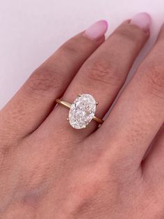 a woman's hand with a ring on it and a diamond in the middle