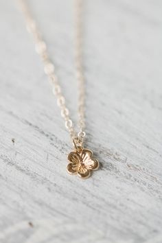 Solid 14k gold cherry blossom charm necklace. A delicate and beautifully detailed charm. Cherry blossoms are a symbolic flower of spring, a time of renewal, and the fleeting nature of life. In Japanese culture the cherry blossom represents the fragility and the beauty of life. Available with a solid gold chain, gold filled chain or as a charm only. Charm comes with a 4mm jump ring, if you would like a spin ring clasp to add to your charm bracelet feel free to contact me.✥  14K Solid gold (charm Charming Flower Pendant Jewelry With Charm, Charming Flower Pendant Jewelry, Dainty Blossom Jewelry For Spring, Dainty Blossom Color Jewelry For Spring, Everyday Flower Charm Jewelry, Delicate Flower Jewelry For Spring, Spring Flower-shaped Jewelry Gift, Cute Gold Jewelry With Flower Charm, Spring Blossom Jewelry With Flower Decoration