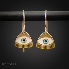 "Discover the enchanting allure of our Evil Eye Triangle Earrings, where mystique meets craftsmanship. At the core of this unique design, the evil eye sits gracefully within a perfectly shaped triangle, symbolizing strength, protection, and divine harmony. This central motif is intricately adorned with colorful resin. Each piece is crafted by hand, ensuring that every detail is laid with precision and care, reflecting the care and attention poured into its creation. ★Comes in our signature gift box, ready for gift giving.  ★ Available in Gold [gold-filled ear wire & gold plated brass with resin ]  ★ Earring size: (evil eye triangle) 0.40\"x0.50\" Thanks for shopping at ByYaeli♥  All images, texts & products are property of ByYaeli ©2024." Adjustable Gold Evil Eye Earrings, Metal Dangle Earrings With Evil Eye, Gold Evil Eye Drop Earrings, Adjustable Teardrop Evil Eye Jewelry, Elegant Evil Eye Earrings As A Gift, Bohemian Evil Eye Earrings As Gift, Elegant Evil Eye Earrings For Gift, Elegant Dangle Earrings With Evil Eye, Nickel-free Gold Triangle Jewelry