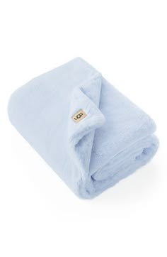 a blue blanket folded up on top of a white surface with a gold tag in the middle