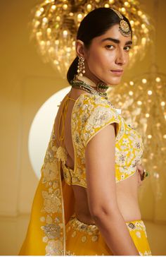 Editor's Note Featuring a lehenga set carrying resham thread work, heavy embellishments of pearls, sequins, stones and cutdana Fabric: Modal Dupion; Organza Color: Yellow Care: Dry Clean Only About the Designer Varun’s work marries the beauty of heritage Indian handcrafted embroideries with a modern colour sensibility. His clothes range from traditional saris and lehenga ensembles to contemporary separates like trousers, tunics, jackets, and dresses. He is known for the lightness of his fabrics Festive Kundan Embellished Traditional Wear, Kundan Choli For Reception And Diwali, Embellished Traditional Wear With Kundan, Festive Embellished Traditional Wear With Kundan, Traditional Embellished Saree Set, Designer Yellow Embellished Sets, Kundan Blouse Piece For Wedding And Diwali, Wedding Kundan Blouse Piece For Diwali, Embellished Kundan Sets For Reception