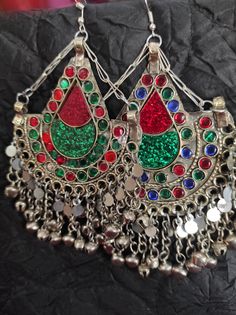 * The astonishing Afghani pair of earrings are an authentic traditional ornament of mountain regions. The pair is beautifully embellished with multi color stones and silver dangling beads. * The tear drop shape like earrings have engraved circular and tear drop designs in which glass stone is embedded. The silver beads at the bottom are nothing but making this piece an epitome of tradition. * You can pair them with any attire or style, traditional or trendy, it is on you. But they would get alon Green Pendant Earrings For Festive Occasions, Multicolor Chandbali Earrings For Festival, Bohemian Jewelry With Traditional Patterns As Gift, Handmade Pendant Earrings For Festive Season, Handmade Festive Pendant Earrings, Traditional Red Teardrop Jewelry, Festive Handmade Pendant Earrings, Traditional Red Earrings For Festival, Multicolor Pendant Earrings For Festivals