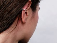 a close up of a person wearing a pair of ear piercings on their ears