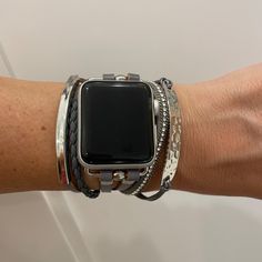 an apple watch on someone's arm wearing bracelets