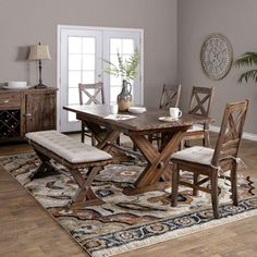 a dining room table and chairs with an area rug on the floor in front of it