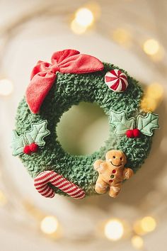 a green wreath with a teddy bear and candy canes on it sitting on a plate