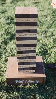 a stack of wooden blocks sitting on top of a grass covered field next to a person