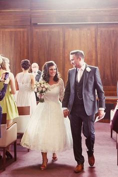 a bride and groom walking down the aisle