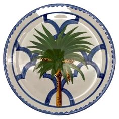 a blue and white plate with a palm tree painted on it