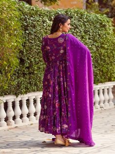 This Set Has a Anarkali, bottom and dupatta. Floral printed tier Anarkali set with hand embroided yoke. It is paired with matching chanderi foil print dupatta enhanced with fabric detailing and palazzo pants. Color: Purple Fabric: Anarkali - Cotton Silk Bottom - Shantoon Dupatta - Chanderi Product Details: Neck Type - Round neck Anarkali Length - 50 inches Bottom Length - 38-40 inches Sleeve Length - 22 inches Note: Available in other colors The product will be delivered within 2-4 weeks of orde Purple Palazzo Set With Sheer Dupatta For Diwali, Purple Georgette Palazzo Set With Traditional Drape, Traditional Drape Purple Georgette Palazzo Set, Purple Anarkali Palazzo Set With Cutdana, Traditional Drape Palazzo Set With Printed Motifs, Purple Anarkali Palazzo Set In Chanderi, Chanderi Sharara For Transitional Season, Festive Purple Palazzo Set With Dupatta, Designer Wear Transitional Mulmul Palazzo Set