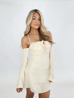 Indulge in luxury with our Della Mini Dress. The smooth satin fabric and soft inner lining provide ultimate comfort, while the front tie detail and bustier design offer a chic, elevated look. Thin straps, off the shoulder long sleeves, and a lace-up back add a touch of trendiness. Perfect for date nights, dinner, drinks, or even a vacation. Embrace the carefree vibes of spring and summer with this elegant and sophisticated dress. Self 97% Polyester 3% Spandex Lining 100% Polyester Hand wash cold Dinner Drinks, Sophisticated Dress, Date Nights, Satin Fabric, Summer Style, Date Night, Off The Shoulder, Lace Up, Hand Wash