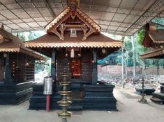 a small wooden structure in the middle of a park with lots of benches around it