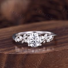 a diamond ring on top of a wooden table with the reflection of it's center stone