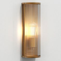 a wall light that is mounted to the side of a wall with a glass shade on it