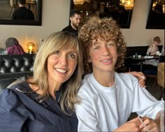 a woman sitting next to a boy in a restaurant