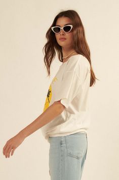 Distressed, garment washed graphic t-shirt. Vintage-style hammock and palm trees smiley face graphic print with "Love Life" text. Torn and distressed detailing at neckline, cuffs, and hem. Round neckline. Short sleeves. Drop shoulder. Oversized fit. 100% Cotton. Imported top designed and printed in LA. Model wears size S. Trendy Frayed Hem Summer T-shirt, Casual Summer T-shirt With Frayed Hem, Trendy Summer T-shirt With Frayed Hem, Trendy T-shirt With Frayed Hem For Summer, Trendy Frayed Hem T-shirt For Summer, Distressed Relaxed Summer Tops, Casual Frayed Hem T-shirt For Summer, Relaxed Distressed Summer Tops, Relaxed Distressed Tops For Summer