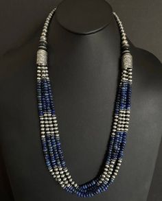 This beautiful multi-strand necklace features genuine lapis and sterling silver pearls beads, strung on a sturdy sterling silver chain. The necklace measures 30 inches in length and is perfect for adding a touch of Southwestern style to any outfit. The combination of the deep blue lapis and the oxidized pearls creates a stunning contrast that is sure to turn heads. The necklace is of high-quality .925 sterling silver and is suitable for daily wear. The beaded design gives it a unique look that is both elegant and casual. It is a perfect gift for someone who loves Southwestern style jewelry. Silver Hand-strung Multi-strand Necklaces, Silver Multi-strand Gemstone Beads, Silver Multi-strand Beaded Necklace With Gemstone Beads, Silver Multi-strand Beaded Necklaces With Gemstone Beads, Silver Multi-strand Beaded Necklaces With Natural Stones, Silver Gemstone Beads In Multi-strand, Traditional Silver Necklace With Lapis Lazuli, Traditional Silver Lapis Lazuli Necklace, Silver Lapis Lazuli Necklace With Polished Beads