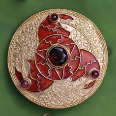 The famous 6th century Triskelion Brooch, as shown in Sutton Hoo collection in British Museum in London, is remarkably ,is reproduced in this vermeil pin, pendant and earrings. Crafted totally by hand as done in the ancient times. The Cloisonne motif is three whirling arms in the form of birds' heads. The eyes of the b Ceremonial Hallmarked Pendant Brooch, Traditional Yellow Gold Collectible Brooch, Ornate Engraved Brooch, Ceremonial Medallion Jewelry With Historical Design, Traditional Yellow Gold Pendant Brooches, Ornate Pendant Brooch For Ceremonial Occasions, Ornate Yellow Gold Brooch For Ceremonial Use, Ceremonial Yellow Gold Brooch With Intricate Design, Ornate Yellow Gold Brooches For Ceremonial Use