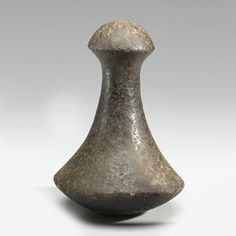 a gray vase sitting on top of a white table