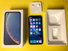 an iphone xr in its box next to it's charger and packaging