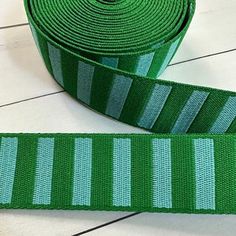 a roll of green ribbon sitting on top of a white floor