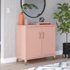 a living room with a pink cabinet and potted plant