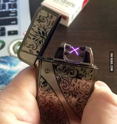 someone is holding two lighters that are shaped like an x and the other one has a purple light on it