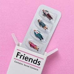 three plastic figures are in a box on a pink background with the words friends printed on it