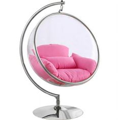 a pink chair sitting inside of a glass ball on top of a metal stand next to a white wall