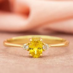 a yellow diamond ring sitting on top of a table