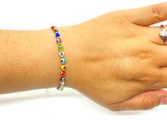 The bracelet is made of round medium sized (4mm) glass eye beads that are multi-colors. They are made with nylon thread and have a woven sliding knot that allows it to fit most wrists. These are a great accessory for any occasion and everyday use. Multicolor Evil Eye Bracelet With Colorful Round Beads, Multicolor Round Evil Eye Bracelets, Multicolor Evil Eye Round Bracelets, Adjustable Multicolor Evil Eye Bracelet With Tiny Beads, Adjustable Evil Eye Bracelet With Colorful Beads, Multicolor Beaded Bracelets With Evil Eye, Adjustable Multicolor Beaded Evil Eye Bracelet, Multicolor Beaded Bracelet With Evil Eye, Multicolor Evil Eye Bracelets