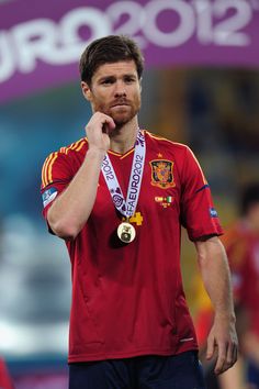 a man with a medal on his neck standing in front of a sign that says euro 2012