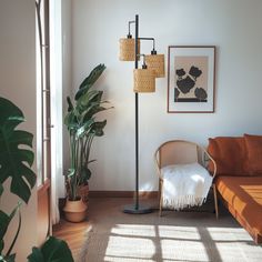 a living room with a couch, chair and floor lamp in the corner next to a potted plant